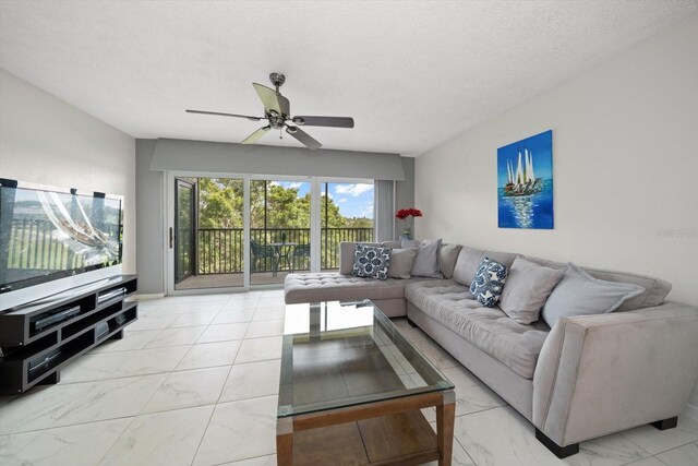 living room with ceiling fan and a textured ceiling