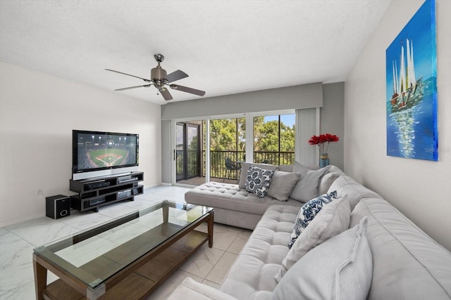 living room featuring ceiling fan and a textured ceiling