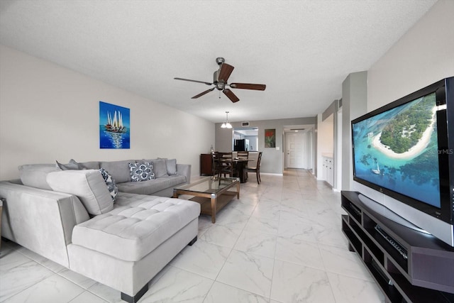 living room featuring a textured ceiling and ceiling fan