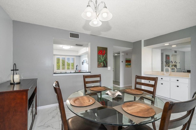 dining room with a chandelier and a textured ceiling