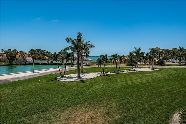 view of home's community featuring a lawn and a water view