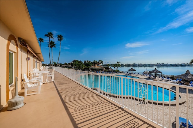 view of pool featuring a patio and a water view