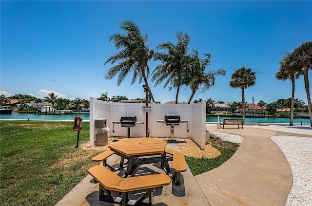 surrounding community featuring a lawn and a water view