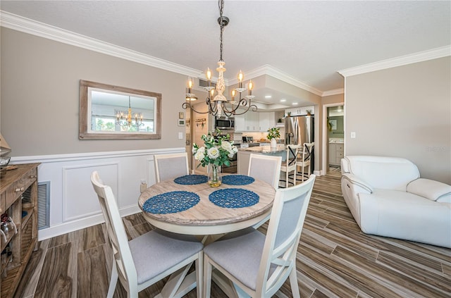 dining room with crown molding and an inviting chandelier