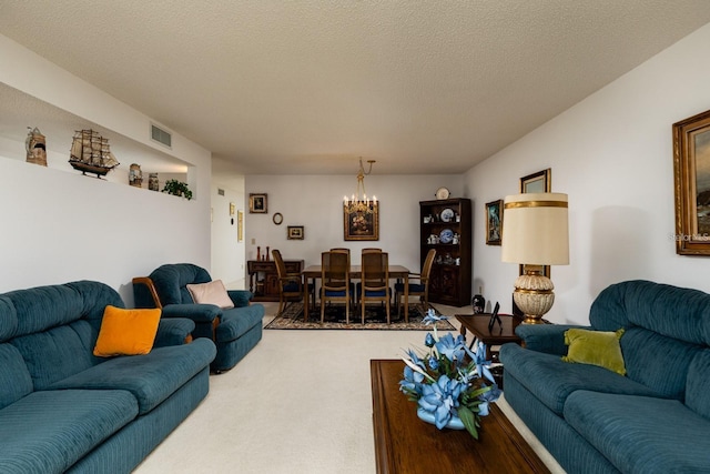 carpeted living room with a chandelier and a textured ceiling