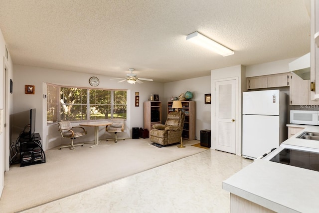 kitchen with light carpet, ceiling fan, sink, white appliances, and a textured ceiling