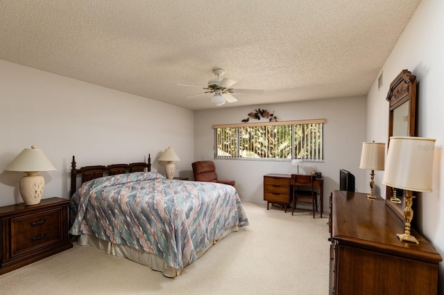 bedroom featuring ceiling fan, a textured ceiling, and light carpet