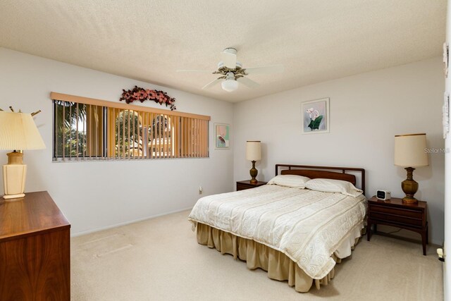 carpeted bedroom featuring a textured ceiling and ceiling fan