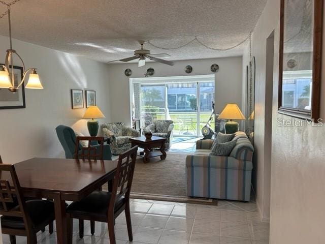 dining room with ceiling fan, light carpet, and a textured ceiling