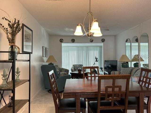 tiled dining room with an inviting chandelier