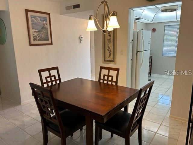 dining room with a notable chandelier and light tile patterned flooring