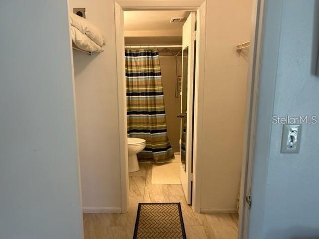 bathroom with a shower with curtain and toilet