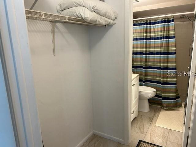 bathroom featuring vanity, a shower with shower curtain, and toilet