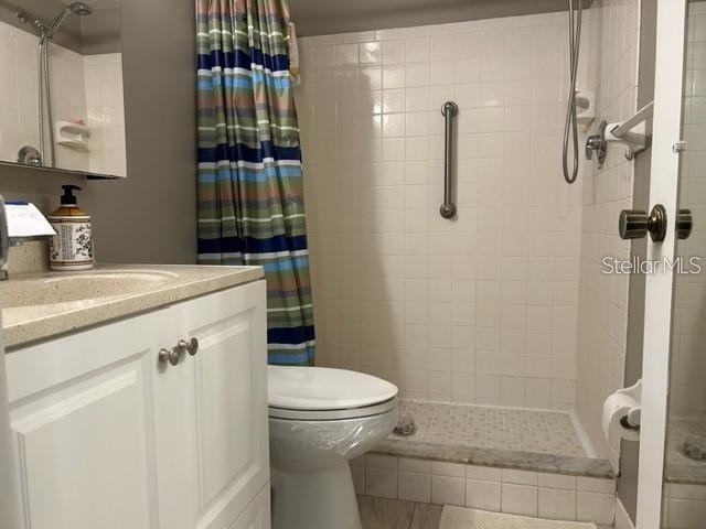 bathroom featuring vanity, toilet, and walk in shower