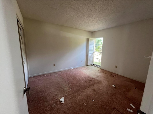 empty room featuring carpet and a textured ceiling