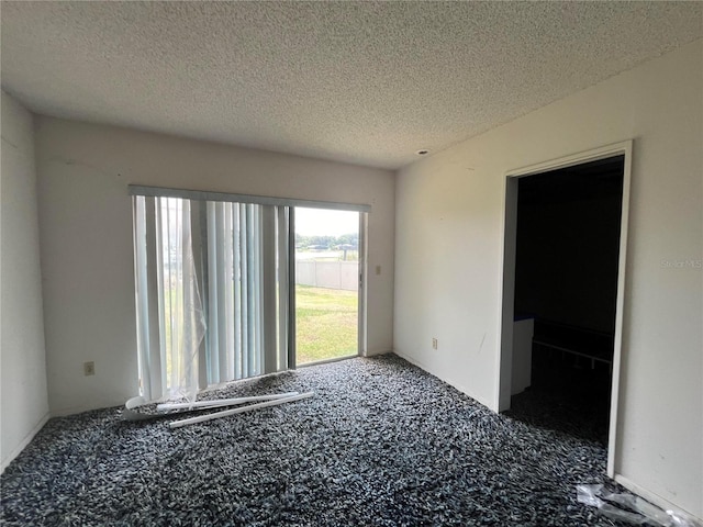 empty room with carpet and a textured ceiling