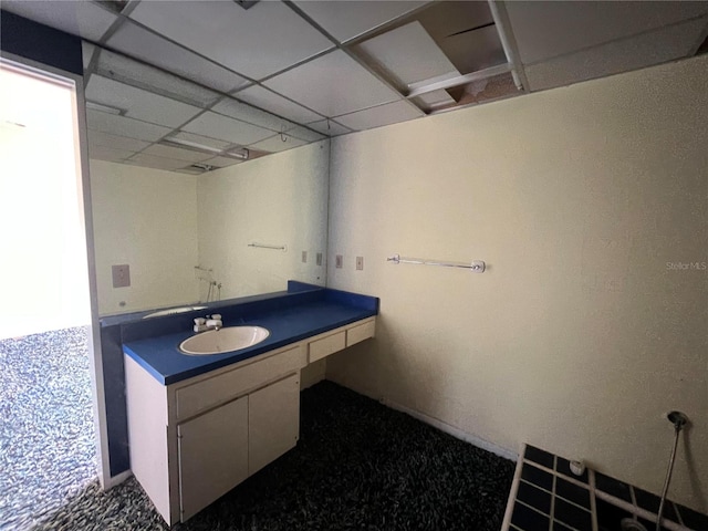 bathroom featuring a paneled ceiling and vanity