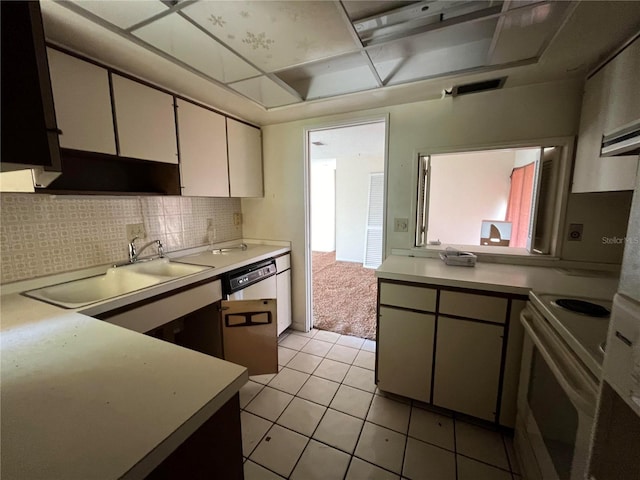 kitchen featuring backsplash, white cabinets, sink, white electric range oven, and light tile patterned flooring