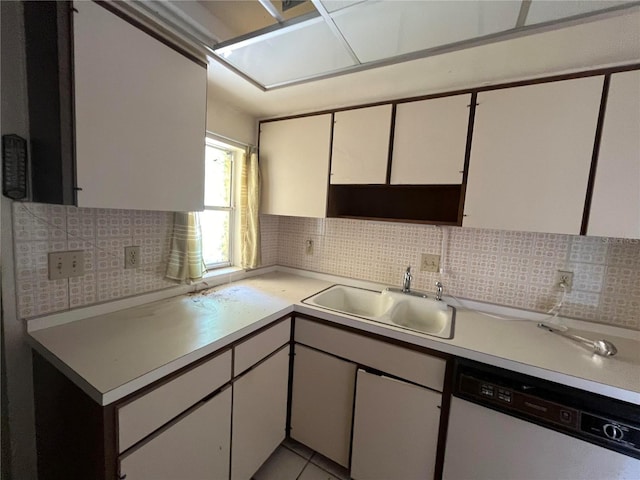 kitchen featuring white cabinets, white dishwasher, tasteful backsplash, and sink