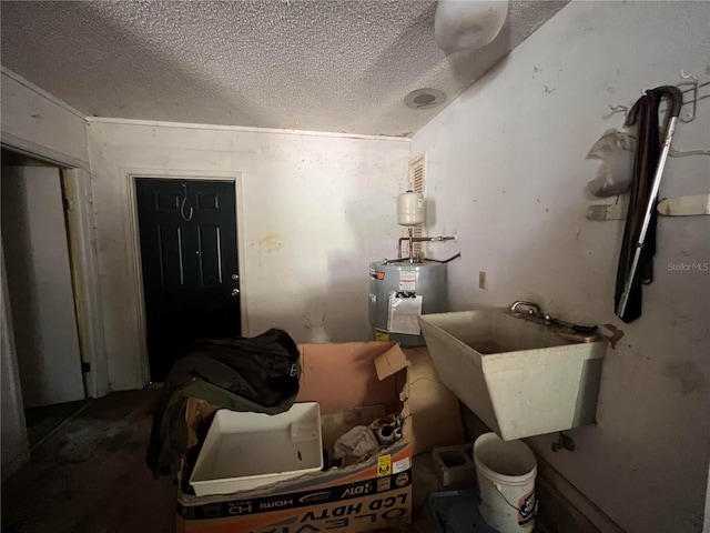 bathroom with a textured ceiling, electric water heater, and sink