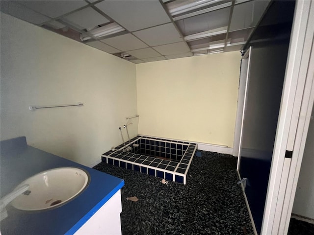 bathroom with a paneled ceiling and sink