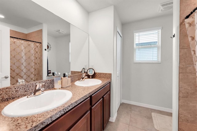 bathroom with tile patterned flooring, vanity, and walk in shower