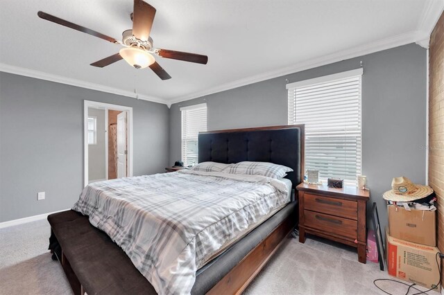 carpeted bedroom featuring ceiling fan and crown molding