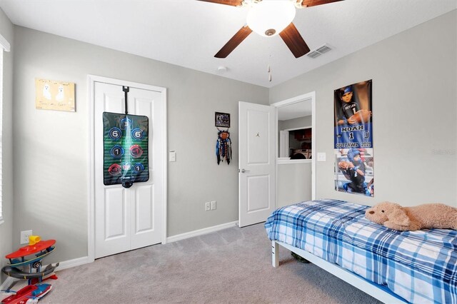 bedroom featuring ceiling fan, light carpet, and a closet