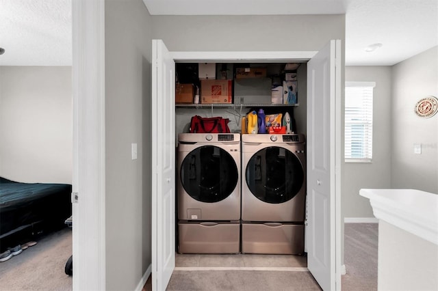 clothes washing area with light colored carpet, a textured ceiling, and independent washer and dryer