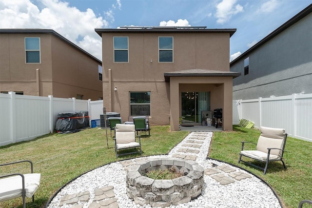 rear view of property with a patio, central AC, an outdoor fire pit, and a lawn