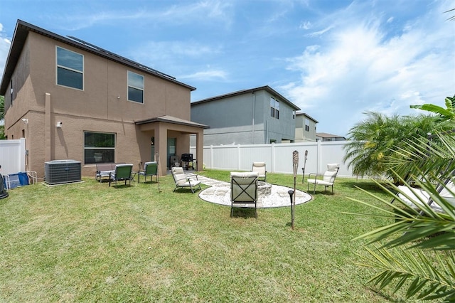 rear view of property featuring a lawn, a patio, and central AC