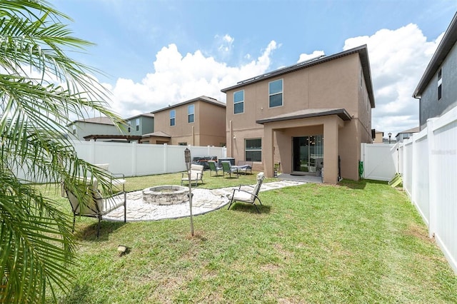 rear view of house featuring a yard, a patio, and an outdoor living space with a fire pit