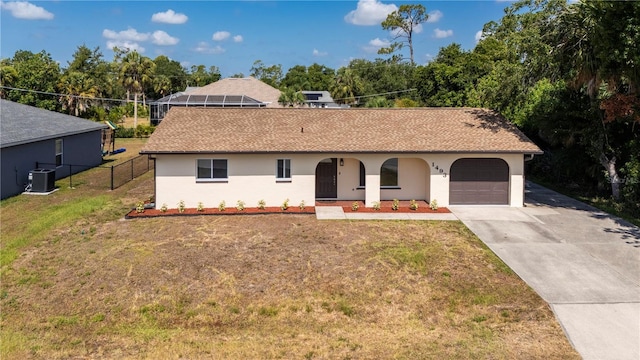 view of front of house with cooling unit, a garage, and a front yard