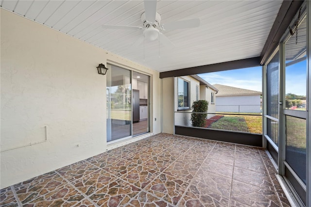 unfurnished sunroom with ceiling fan