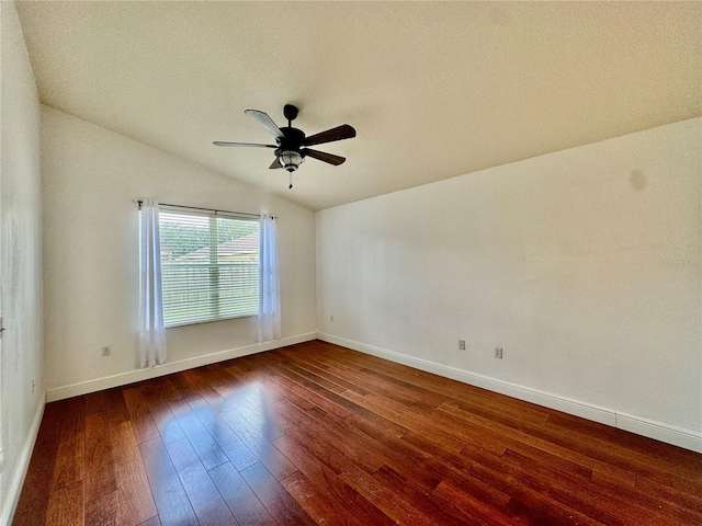 empty room with vaulted ceiling, a textured ceiling, ceiling fan, and dark hardwood / wood-style floors