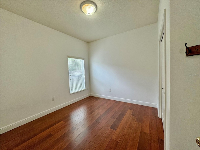 unfurnished bedroom featuring a textured ceiling and dark hardwood / wood-style flooring