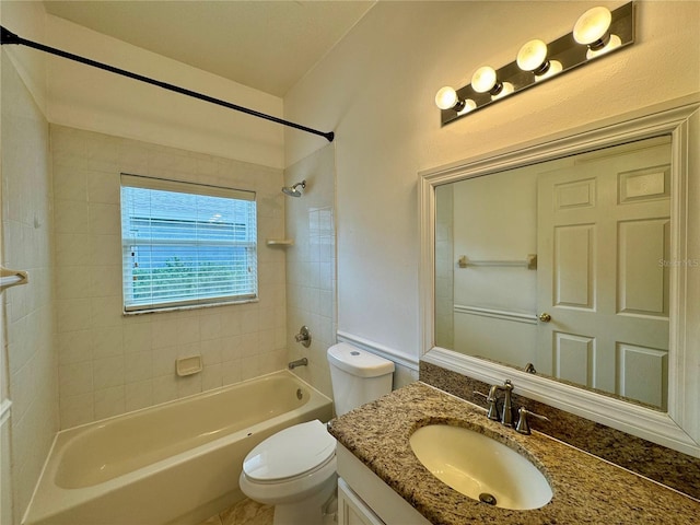 full bathroom featuring tiled shower / bath, toilet, and vanity