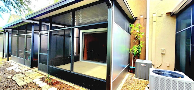 view of side of property featuring central AC unit and a sunroom