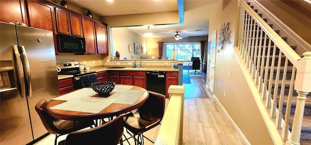 kitchen with sink, black appliances, kitchen peninsula, and ceiling fan