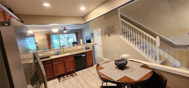 kitchen with black dishwasher, sink, light hardwood / wood-style floors, and decorative light fixtures