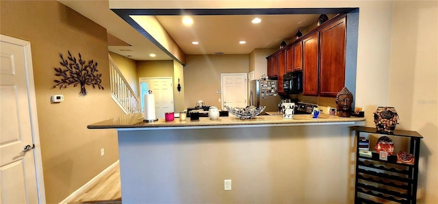 kitchen with range, stainless steel fridge, and kitchen peninsula