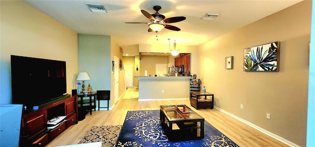 living room with ceiling fan and light hardwood / wood-style floors