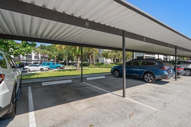 view of parking / parking lot with a carport and a lawn