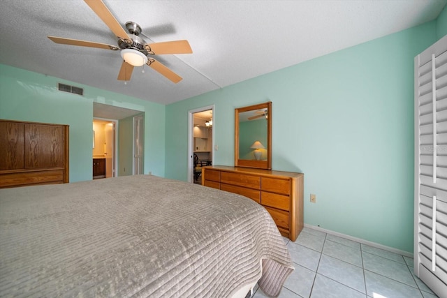 bedroom with light tile patterned floors, connected bathroom, a textured ceiling, and ceiling fan