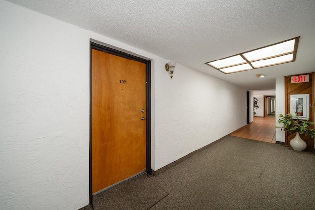 hall with tile patterned flooring and a textured ceiling