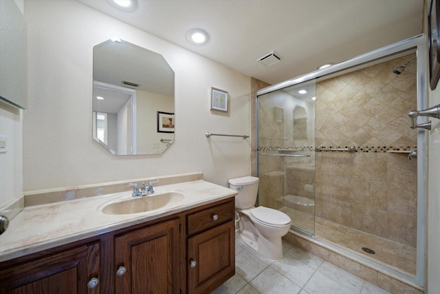 bathroom featuring tile patterned flooring, a shower with door, vanity, and toilet