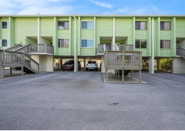 318 Windrush Blvd Unit 9, Indian Rocks Beach, FL 33785 - rear view of house featuring stairway and covered parking