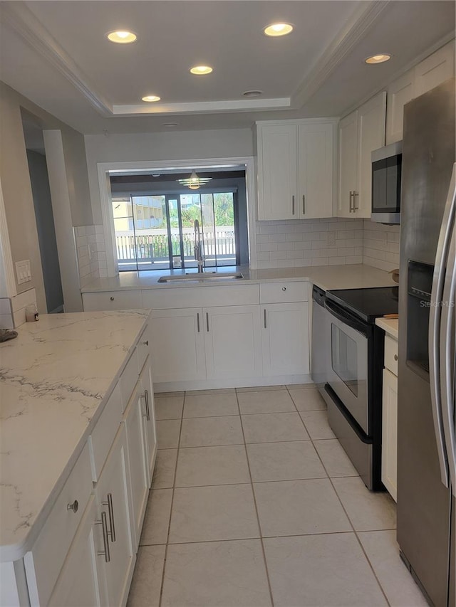 318 Windrush Blvd Unit 9, Indian Rocks Beach, FL 33785 - kitchen featuring stainless steel appliances, a tray ceiling, a sink, backsplash, and recessed lighting