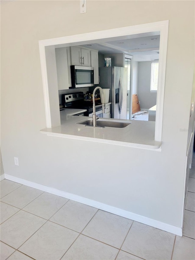 kitchen featuring gray cabinets, light tile flooring, and appliances with stainless steel finishes