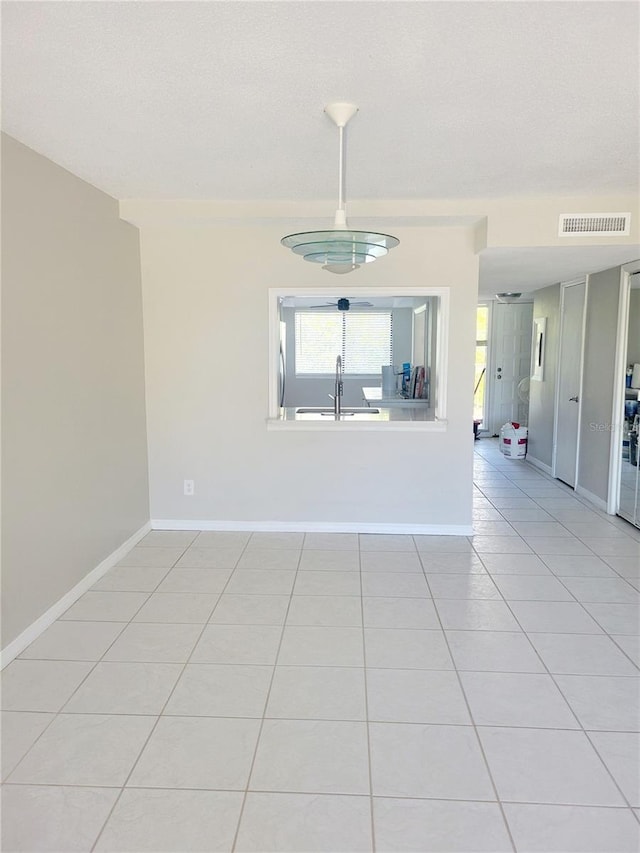 empty room featuring sink and light tile floors